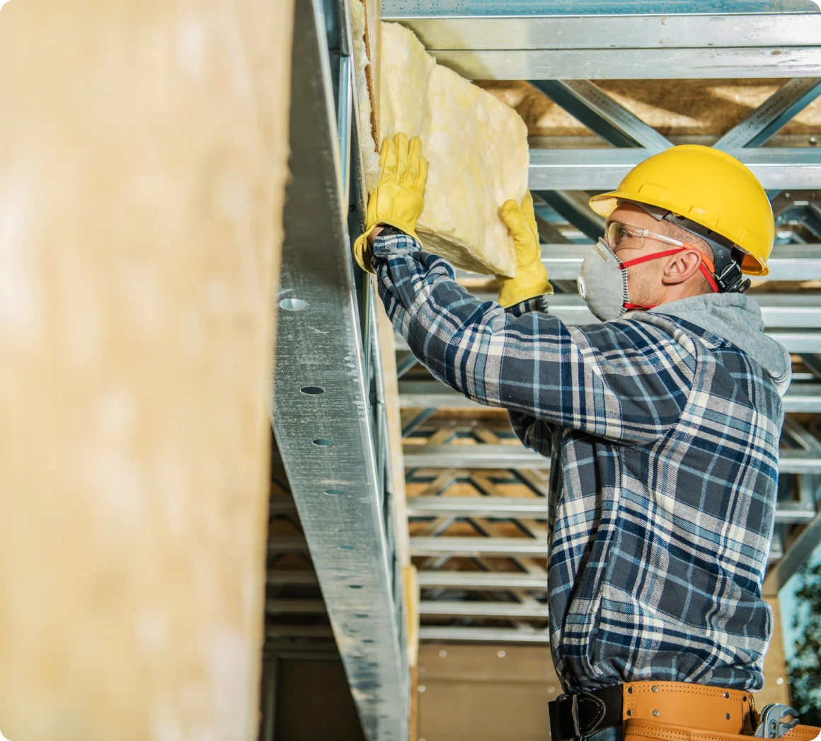 Construction worker installing insulation material