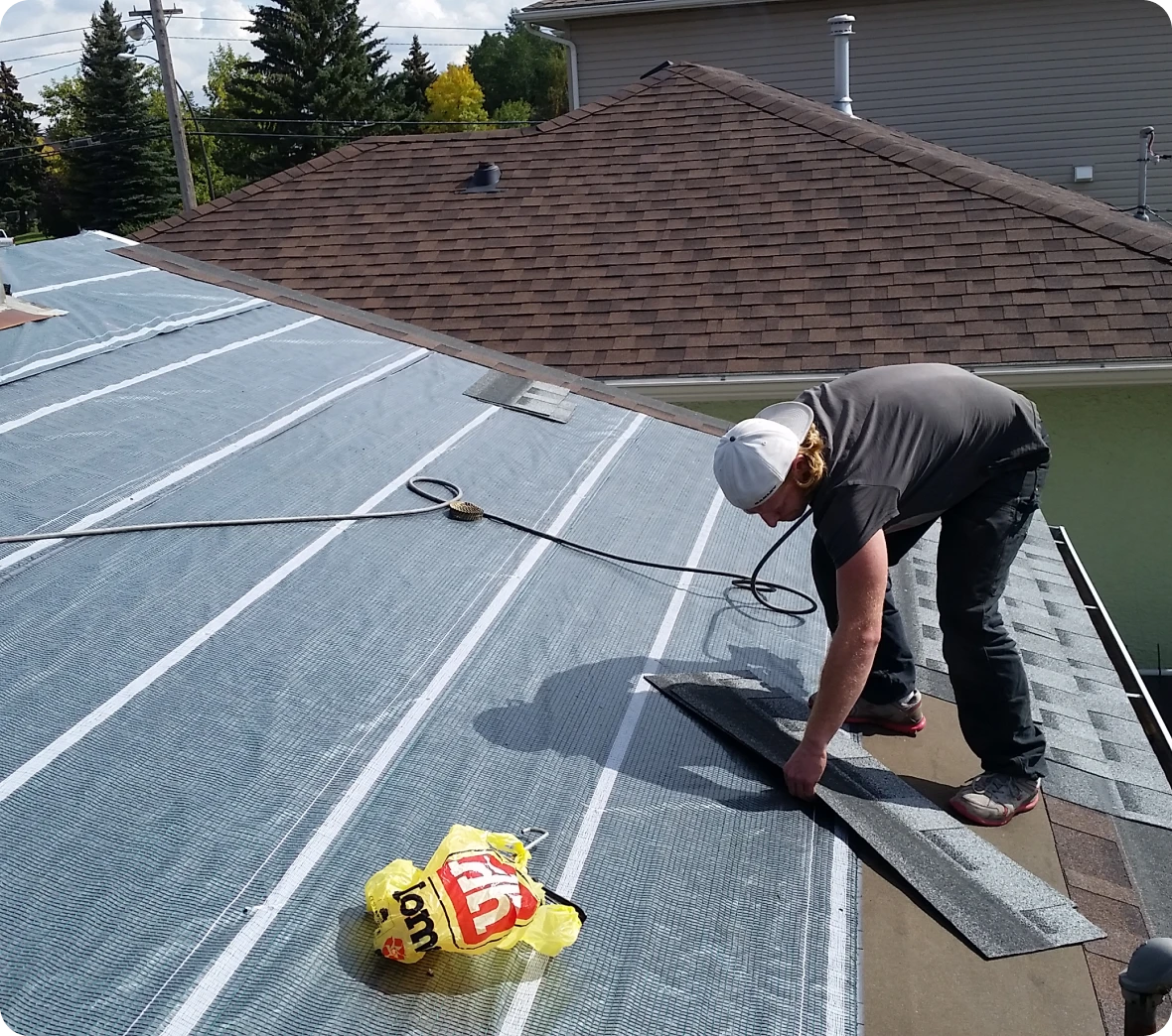 Roofer working on shingle installation